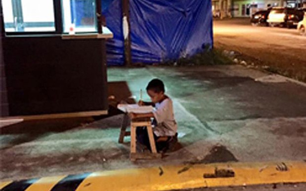 Трогателно: Бездомно дете използва светлината от заведение за бързо хранене, за да напише домашното си
